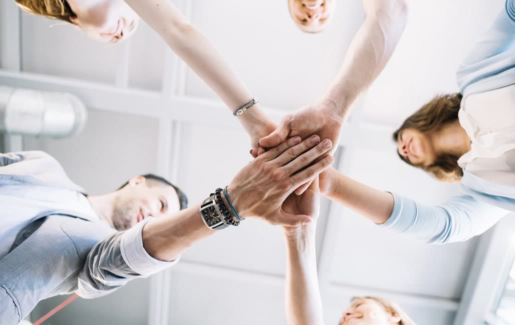 Hände eines Teams übereinander